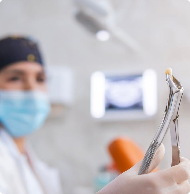 dentist holding extracted tooth with tool