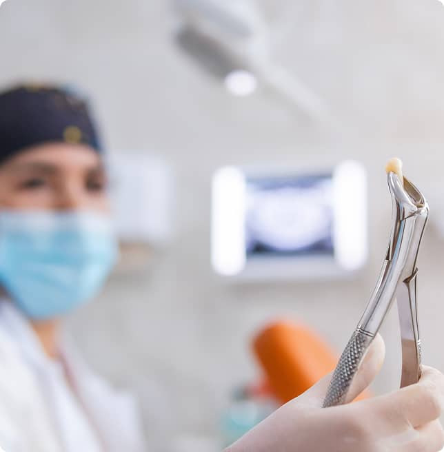 dentist holding tooth with pliers