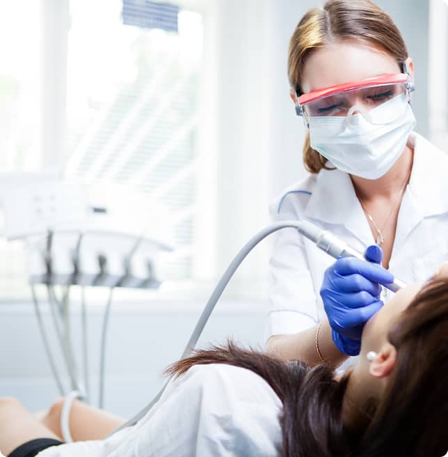 dental hygienist cleaning patient's teeth