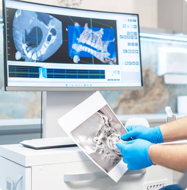 dentsit examining a patient's oral xray