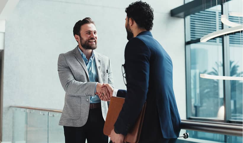 two men in business attire shaking hands