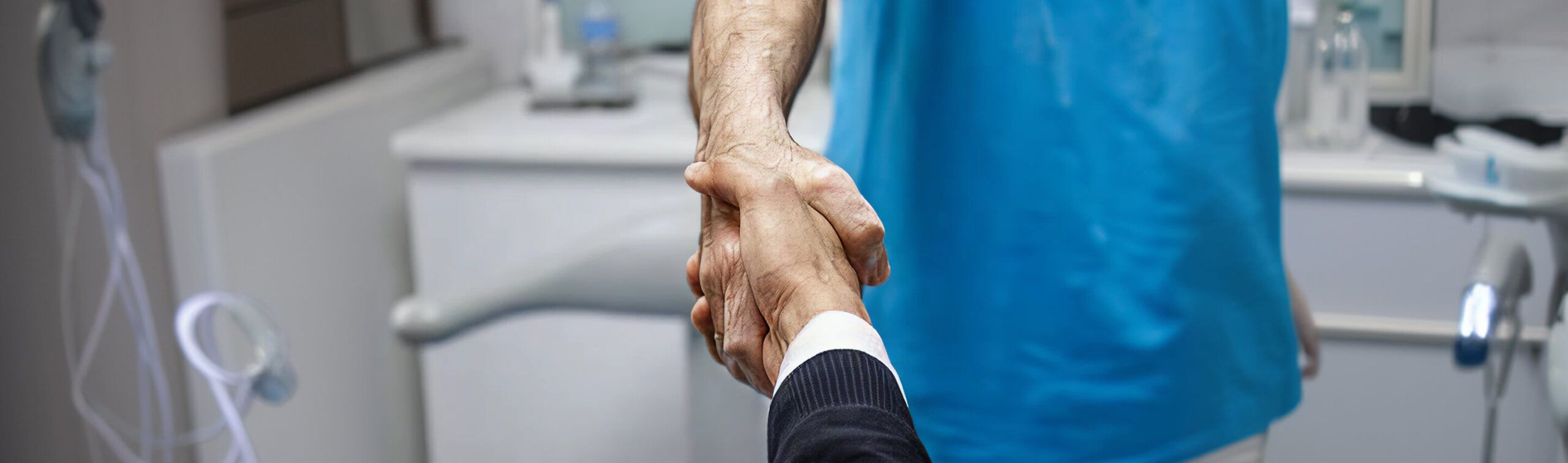 Business man shaking hands with a dentist