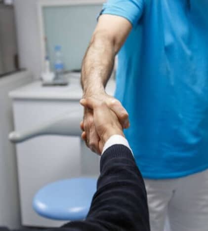 Business man shaking hands with a dentist